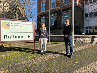 Foto von Vorständin der WIR Westerwälder und Wirtschaftsförderer Tim Kraft neben dem Wegweiser der Rathaus in Kirchen