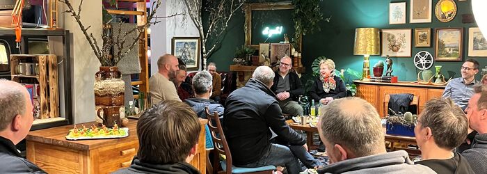 Personen sitzen im Stuhlkreis und tauschen sich beim Netzwerktreffen aus